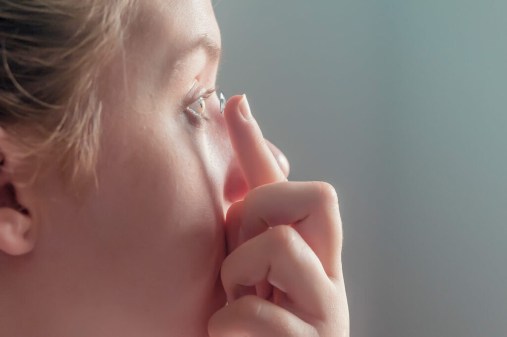 Femme enlevant ses lentilles de contact irritées