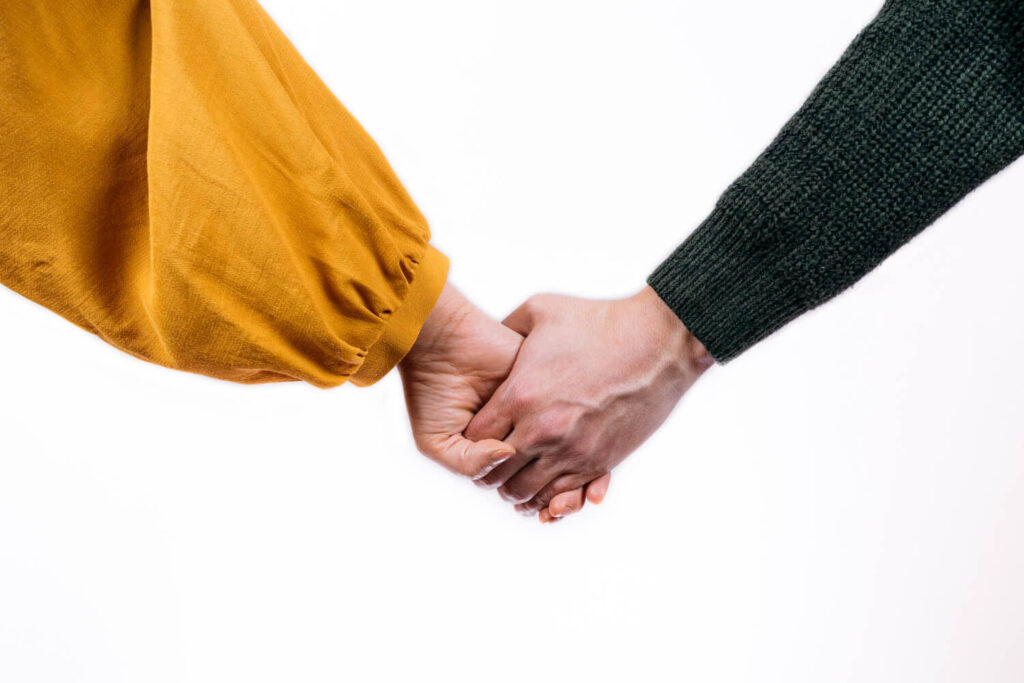 Deux personnes se tenant la main illustrant la différence entre tenir à quelqu'un et aimer