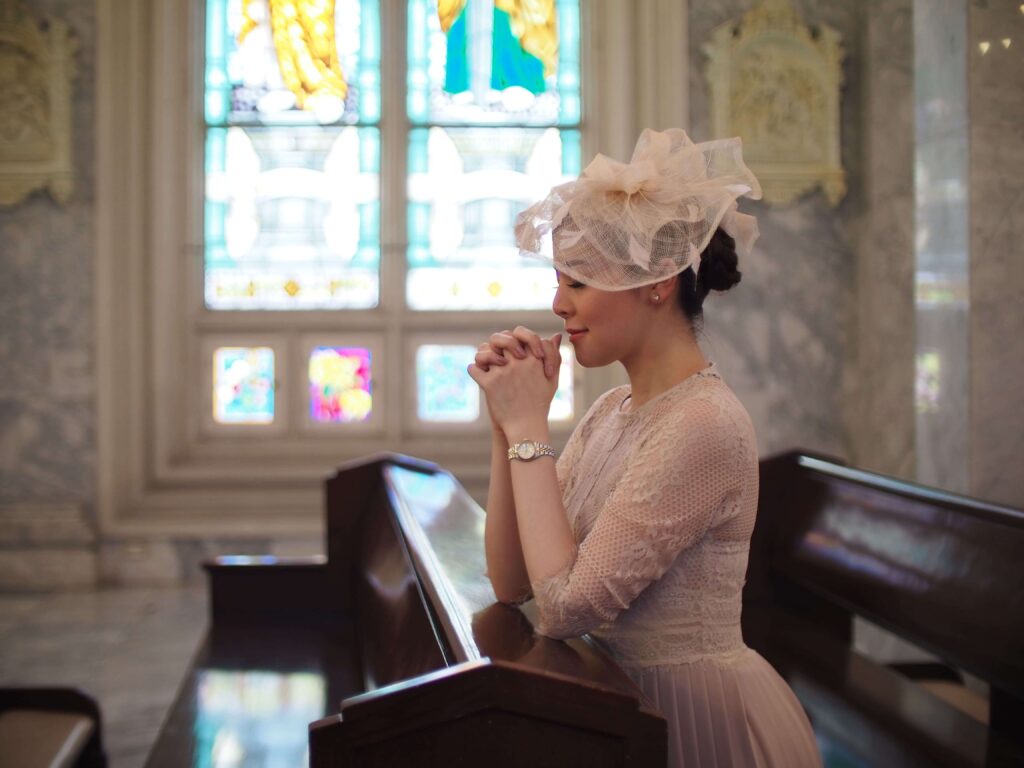 Femme portant une robe pastel élégante dans une église pendant une cérémonie de baptême