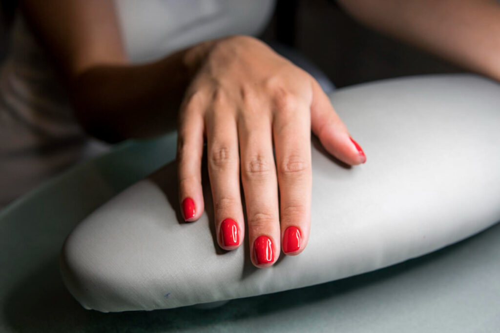 Manucure parfaite illustrant la technique du vernis semi-permanent renforcé sur des ongles pour plus de solidité.