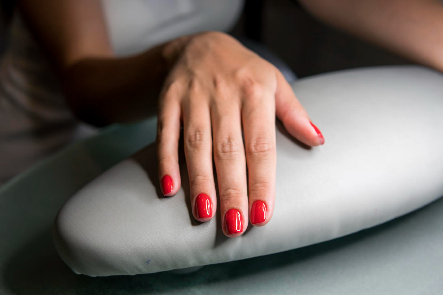 Manucure parfaite illustrant la technique du vernis semi-permanent renforcé sur des ongles pour plus de solidité.