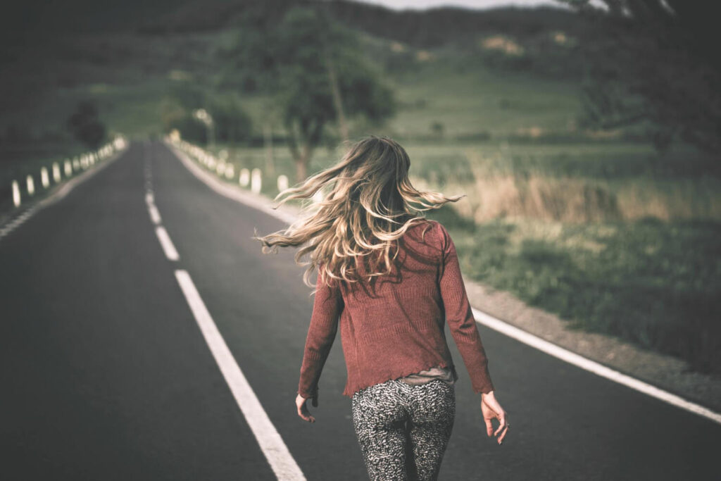 Femme avançant sur un chemin, illustrant combien de temps laisser réfléchir un homme.