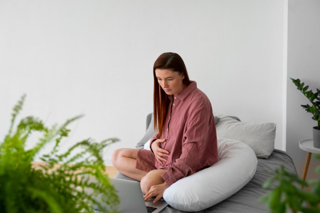 Balise Alt : Femme enceinte se tenant le ventre, inquiète des risques d'une coloration faite pendant sa grossesse.