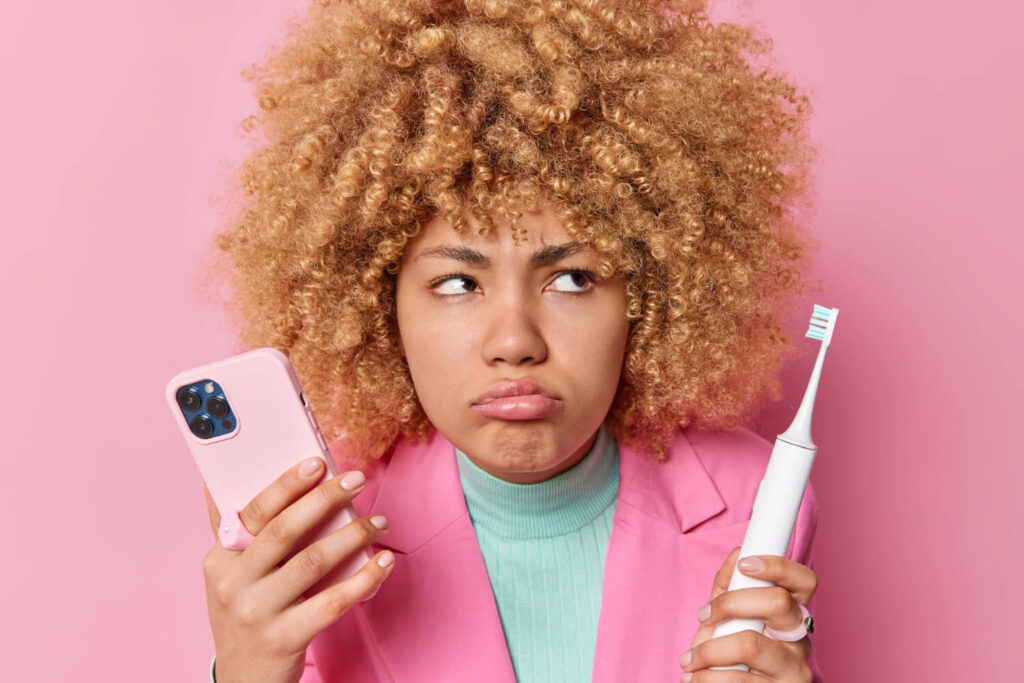 femme avec une brosse à dent électrique