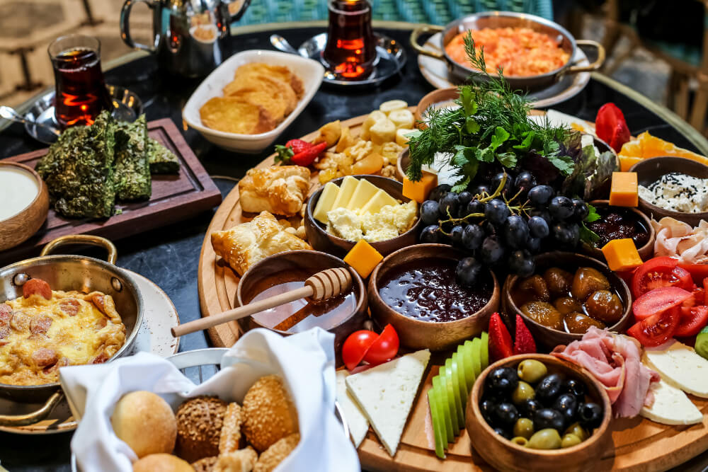 Grande tablée conviviale avec des plats de type buffet, comme des salades composées et des quiches.
