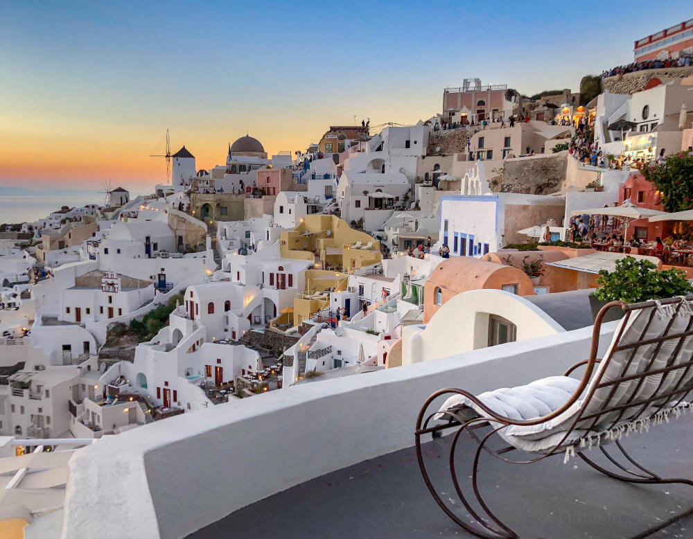 Une semaine à Santorin : est-ce trop long ? 1 Vue iconique des dômes bleus et des maisons blanches d'Oia à Santorin au coucher du soleil.