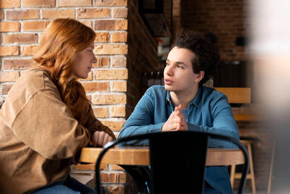 Femme écoutant attentivement un homme qui semble pensif ou nostalgique.