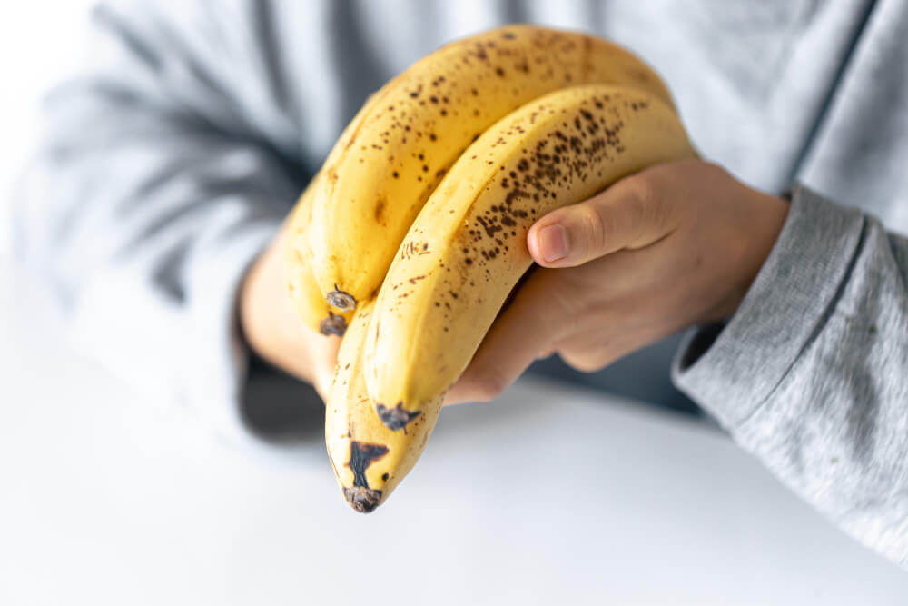 Gros plan sur une banane coupée montrant ses fibres noires, cause fréquente de points noirs dans les selles.