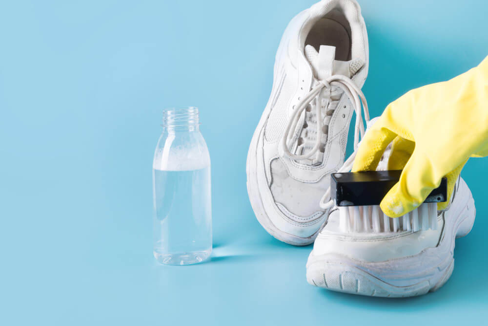 Saupoudrage de bicarbonate de soude à l'intérieur d'une paire de baskets pour désodoriser.