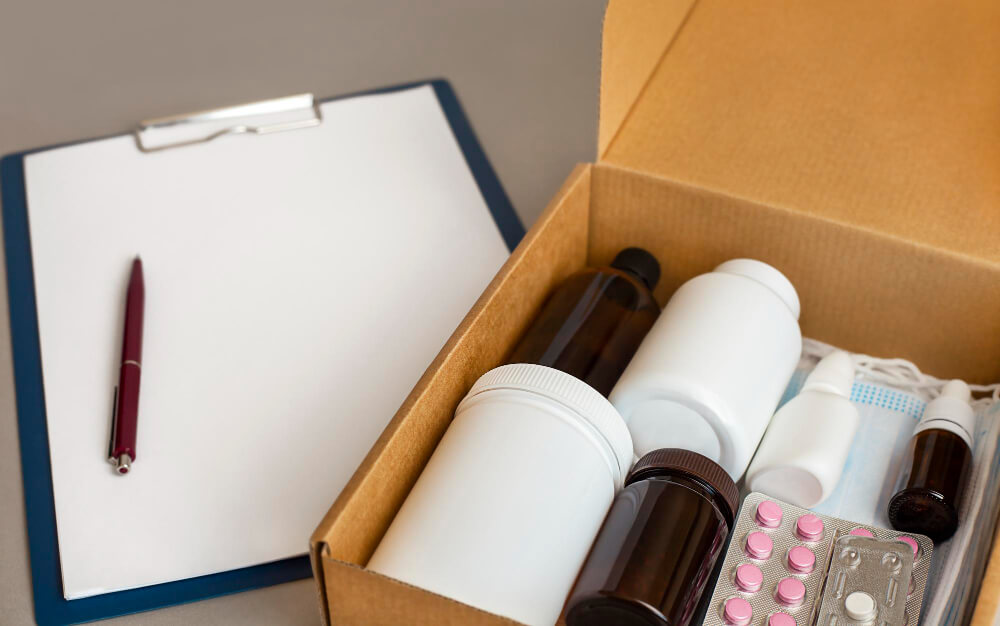 Colis postal ouvert contenant des boîtes de médicaments et une ordonnance, prêt à l'expédition.