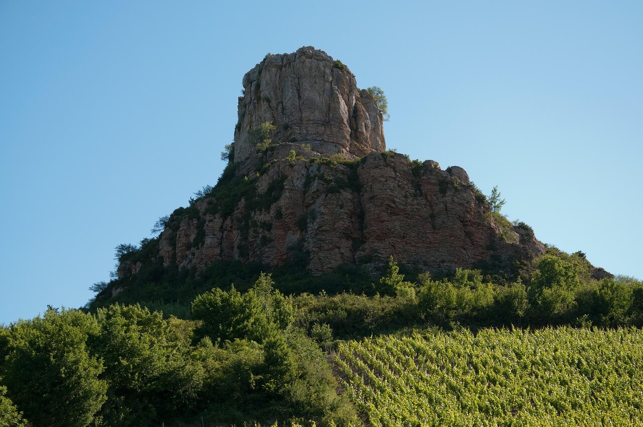 Vue du sentier menant au sommet de la Roche de Solutré, avec les vignobles du Mâconnais en arrière-plan.