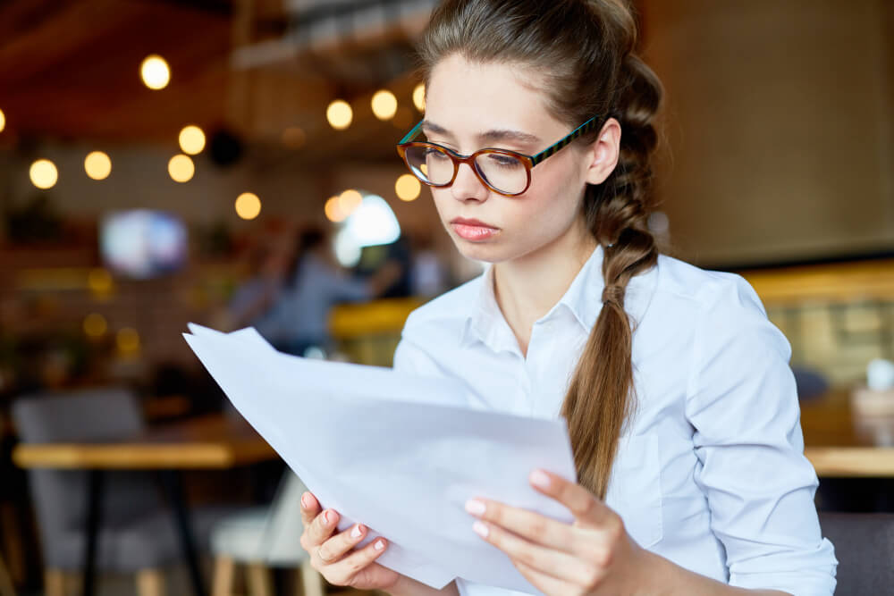 Élève de première regardant son bulletin de notes avec inquiétude pour son dossier Parcoursup