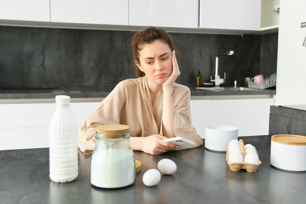 Femme touchant ses joues gonflées, s'interrogeant sur une réaction allergique alimentaire