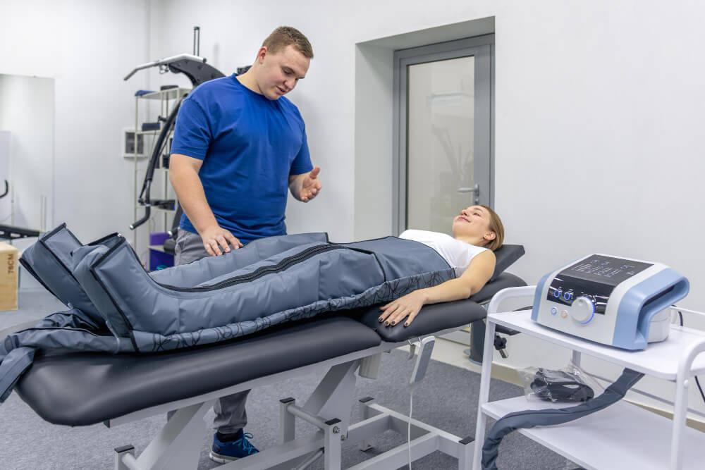 Femme détendue pendant une séance de pressothérapie avec des bottes de compression.