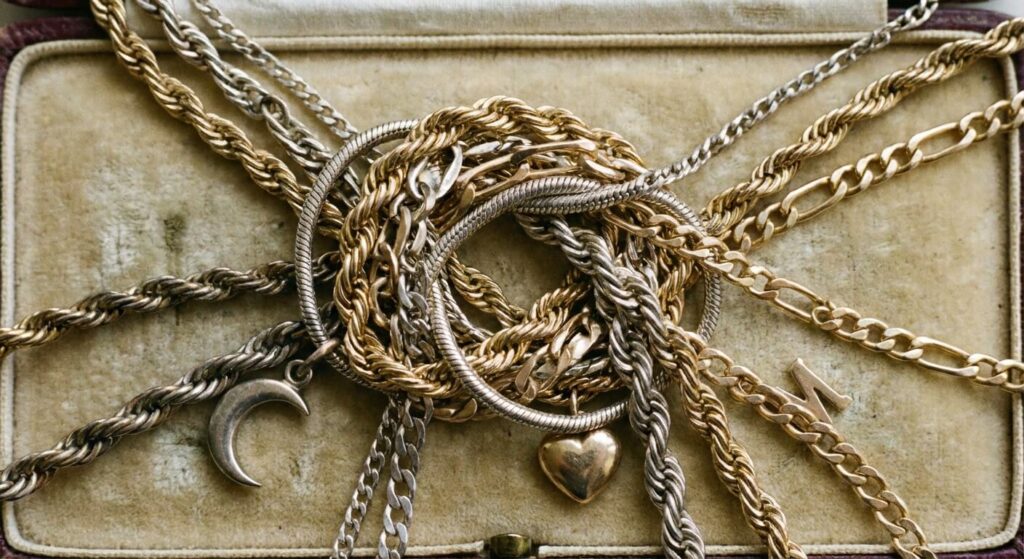 Collier qui s'emmêle tout seul : Signification spirituelle et message caché 2 Chaînes de colliers en or et argent emmêlées formant un nœud complexe