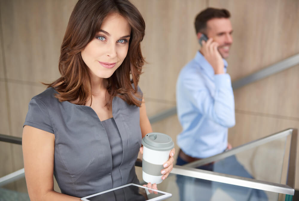 Femme pensive et souriante attendant qu'un homme fasse le premier pas pour engager la conversation