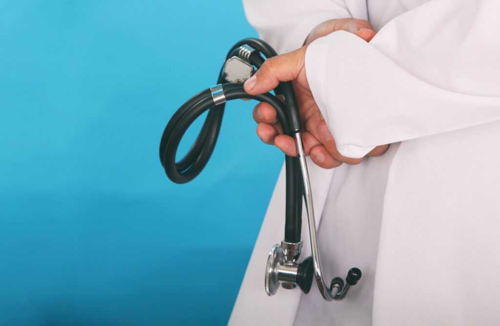 Médecin examinant un stéthoscope, symbolisant la rigueur scientifique