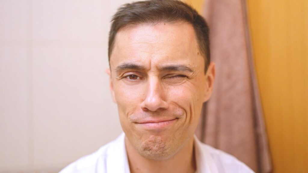 Portrait d'un homme de 40 ans au visage glabre, souriant avec assurance.