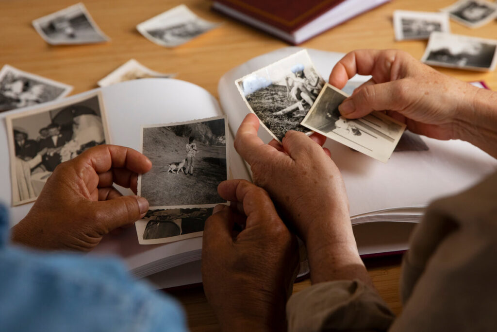 Une personne regardant d'anciennes photographies de sa jeunesse avec émotion et nostalgie.