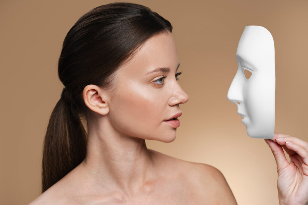 Visage plat : comprendre cette morphologie et comment la mettre en valeur 2 Une femme de profil observant les volumes et les reliefs de son visage dans un studio de visagisme.