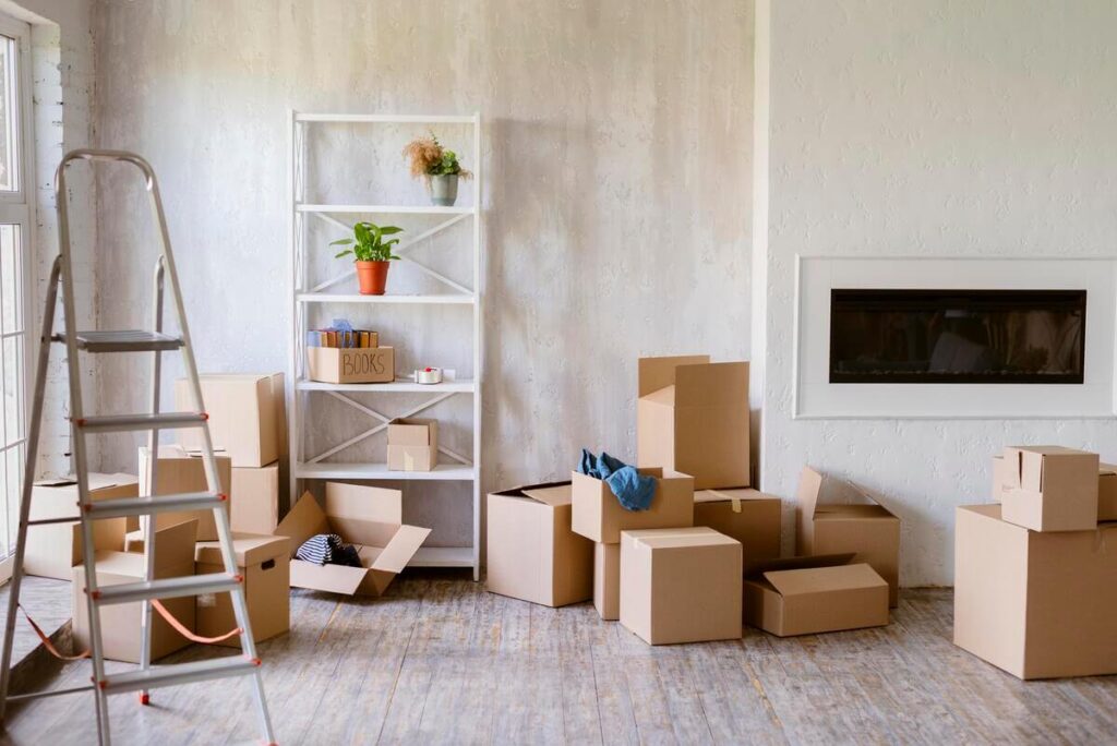 Des cartons de déménagement empilés dans le couloir d'un appartement après une rupture.