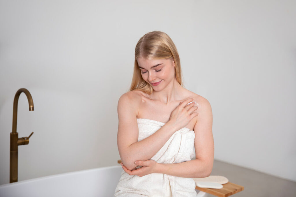 Une personne appliquant un produit éclaircissant sur le bras avec un coton.