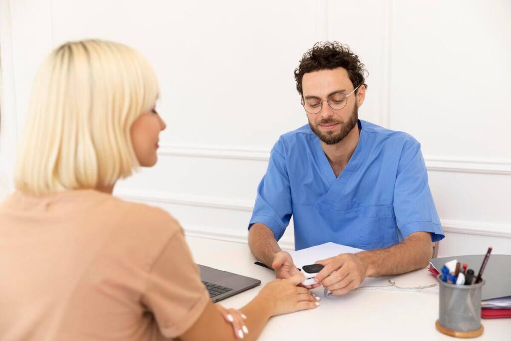 Un professionnel de santé discutant calmement avec une personne dans un bureau médical lumineux.