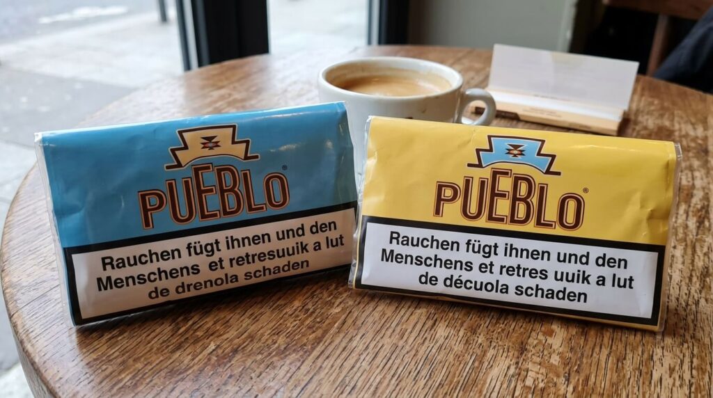 Tabac Pueblo bleu ou jaune : quelle différence ? 2 Deux paquets de tabac à rouler Pueblo, l'un bleu et l'un jaune, posés côte à côte.
