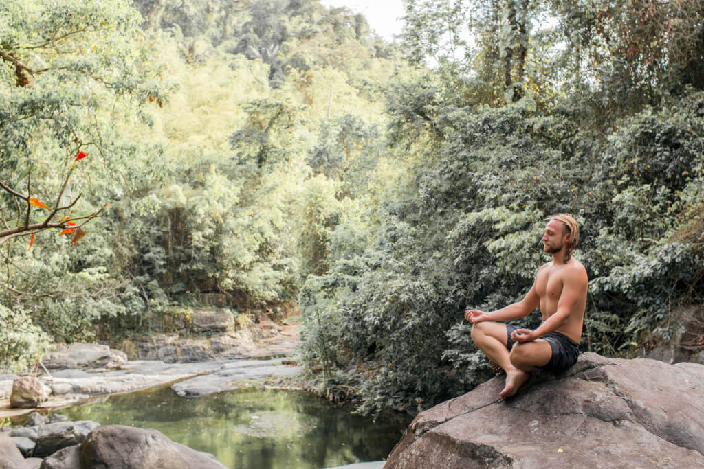 Envie de partir loin sans prévenir personne : fuite passagère ou signal d'alarme ? 3 Une personne assise en forêt profitant d'un moment de calme et de méditation.