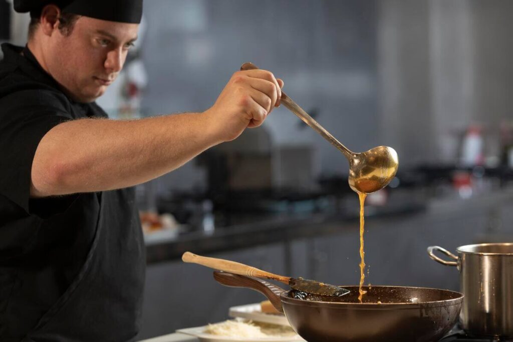 Un cuisinier préparant un plat traditionnel avec des ingrédients frais du terroir dans un faitout en fonte.