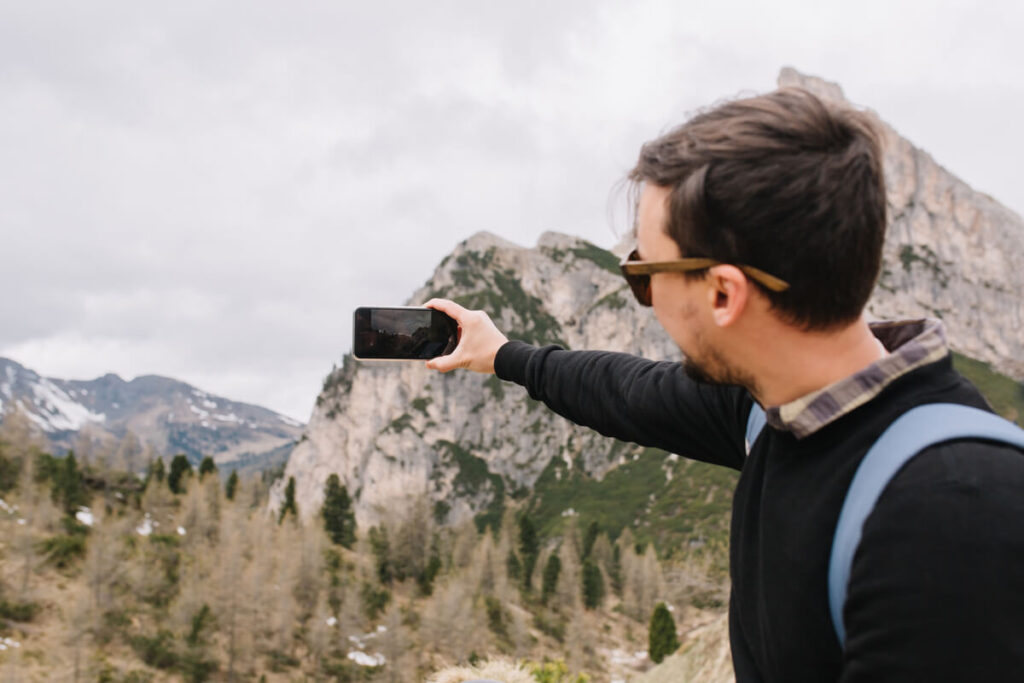 Devenir testeur de voyage : les étapes pour être payé à voyager 4 Un créateur de contenu équipé d'un appareil photo prenant des clichés d'un paysage naturel exceptionnel lors d'une mission de test.