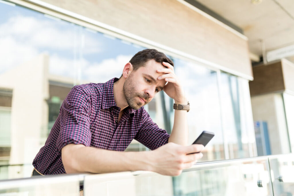 On devait se voir mais pas de nouvelles : raisons, réaction et message 2 Personne regardant son téléphone sans réponse le jour d'un rendez-vous prévu.