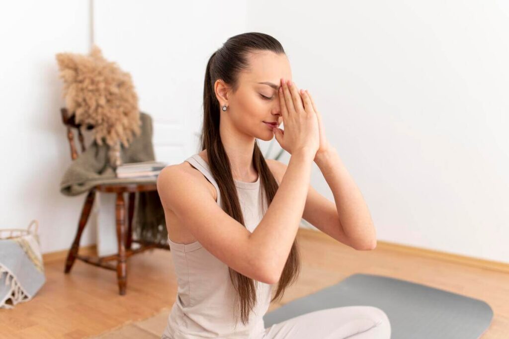 Personne en méditation touchant son front en exprimant un inconfort ou un maux de tête.