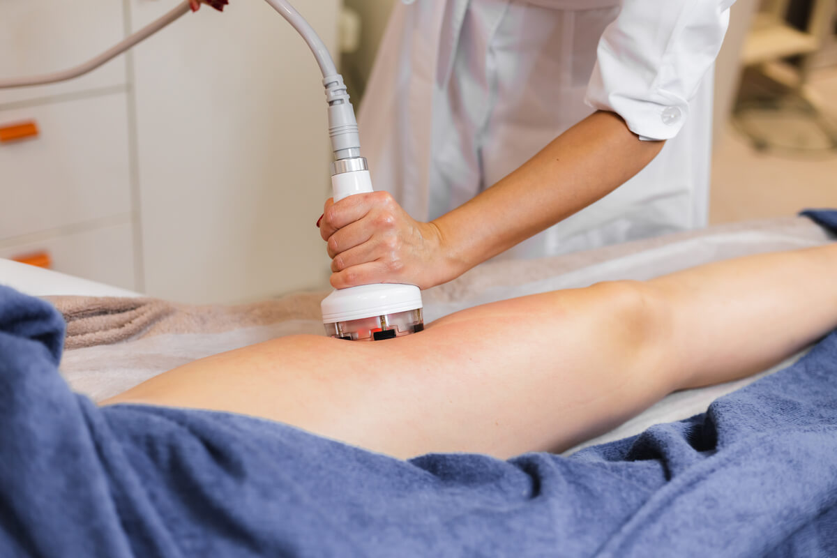Praticienne appliquant la tête de traitement mécanique Starvac sur les cuisses pour déloger la cellulite.