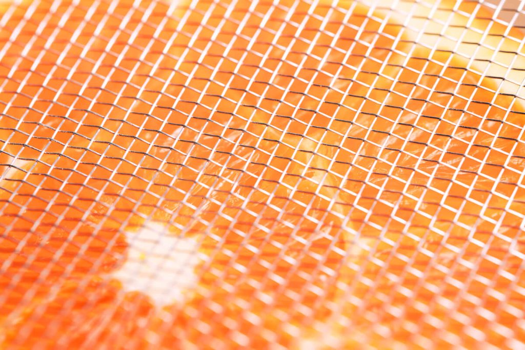Gros plan sur la maille textile micro-perforée laissant passer les rayons UV du soleil.