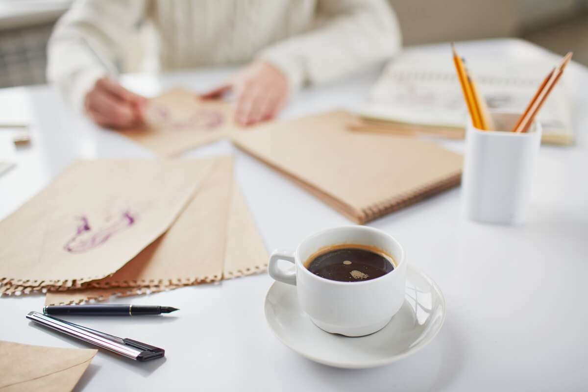 Tasse de café fumante posée sur un bureau de travail illustrant un rythme ralenti.